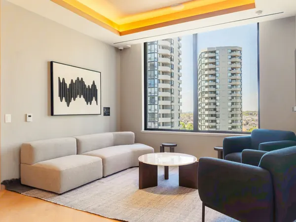 Living room with a modular sofa and a window onto neighbouring towers