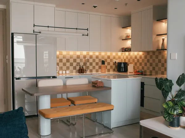 White kitchen with a breakfast island and warm under-cabinet lights