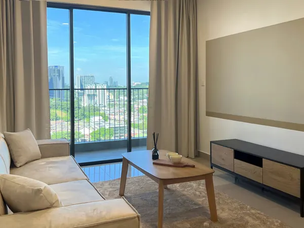 Living room with a linen sofa and a window over treetops and towers