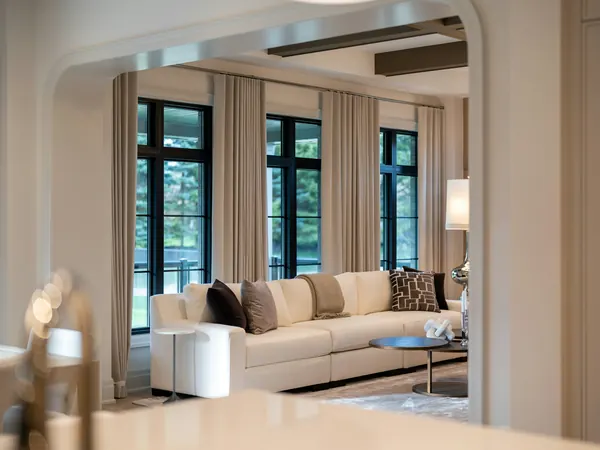 Formal living room with cream sofas and tall black-framed windows